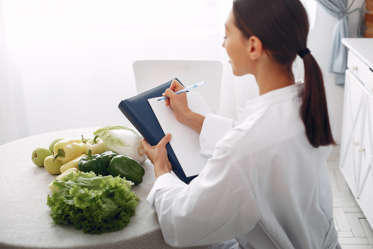Beautiful doctor in a kitchen with a vegetables